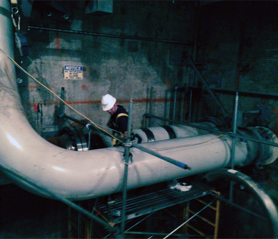 Technician Assessing Heat Exchanger Pipe Condition